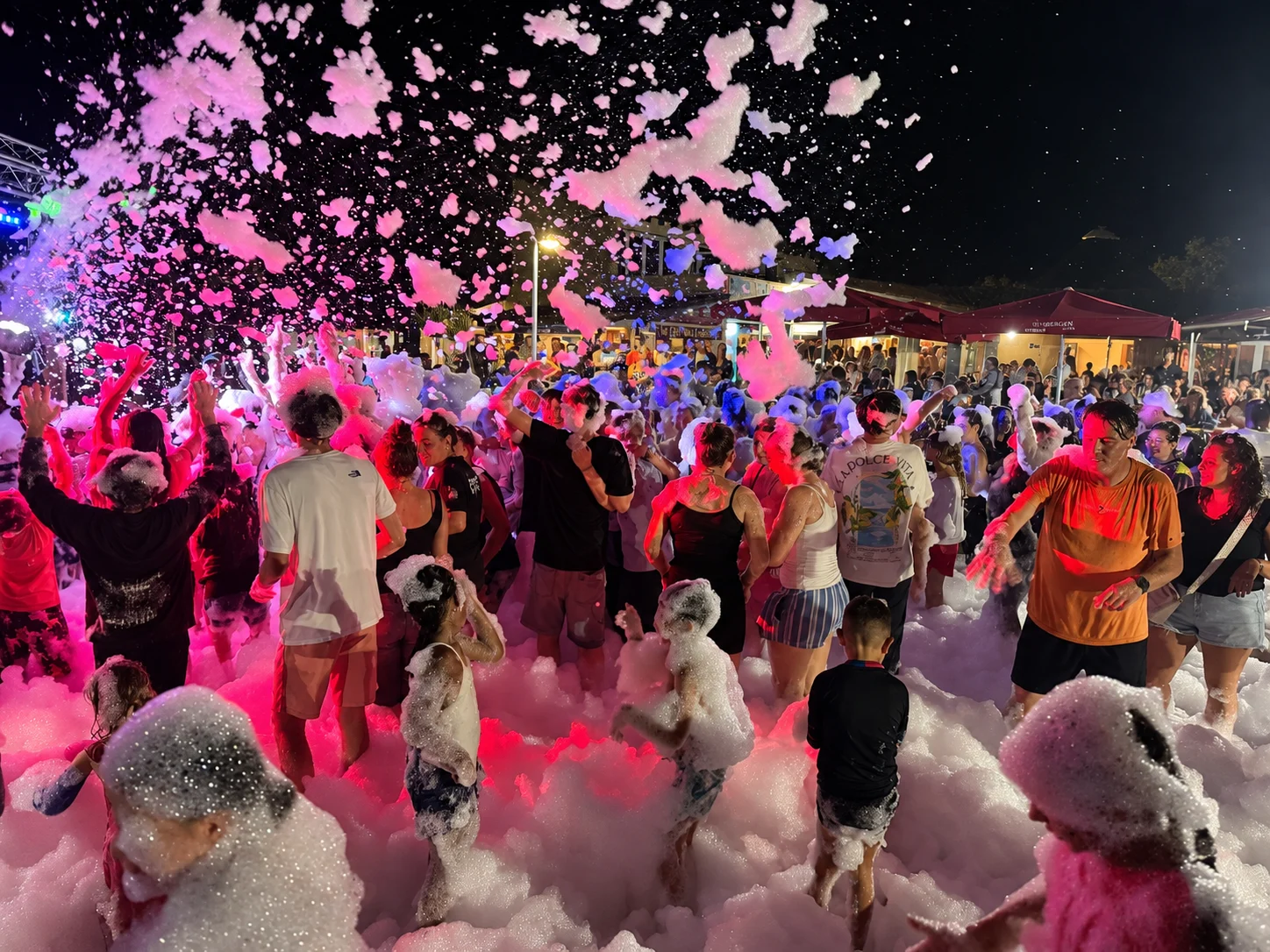 Les participants à une soirée mousse sous les lumières colorées